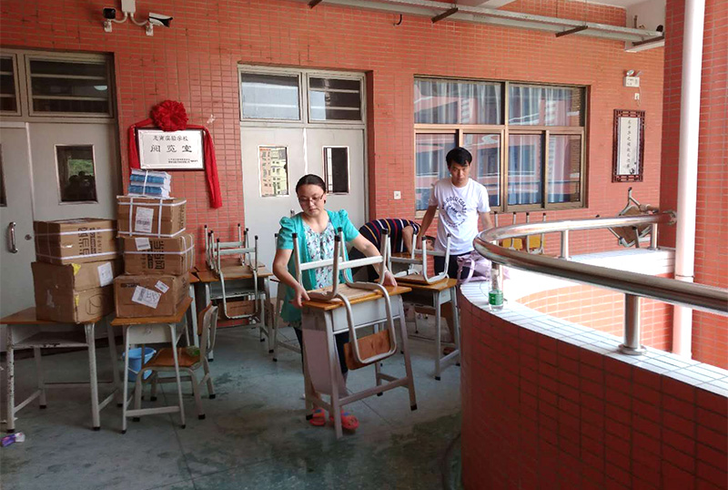 8868体育首页登录志愿者及家长用消毒液擦拭桌椅
